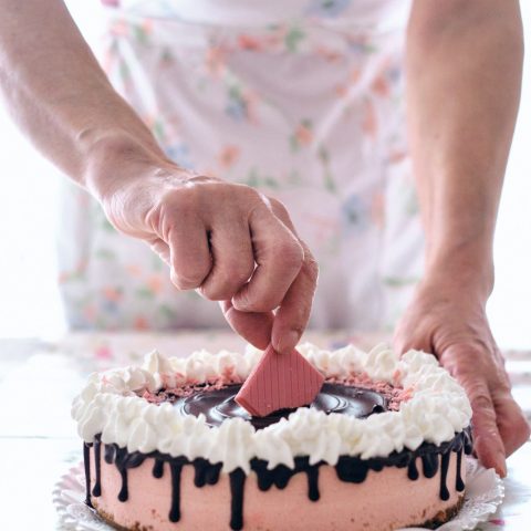 Manos de la repostera trabajando la decoracion de la tarta